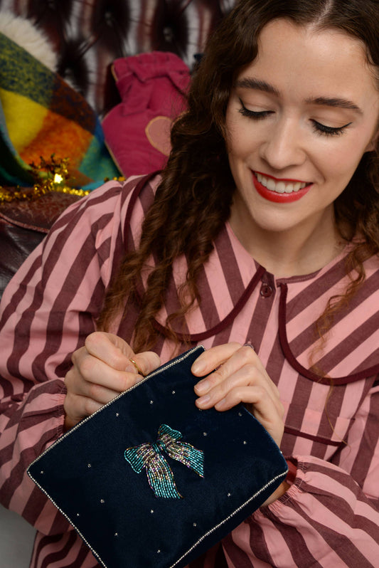 My Doris navy blue clutch pouch with a decorative bow and bead embellishments.