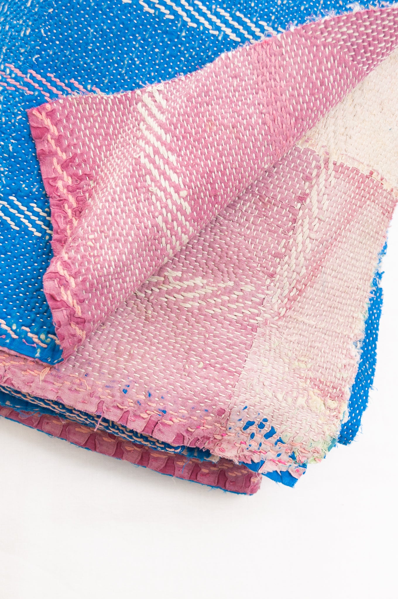 Vintage kantha quilt in cobalt blue stitched in pink and white.