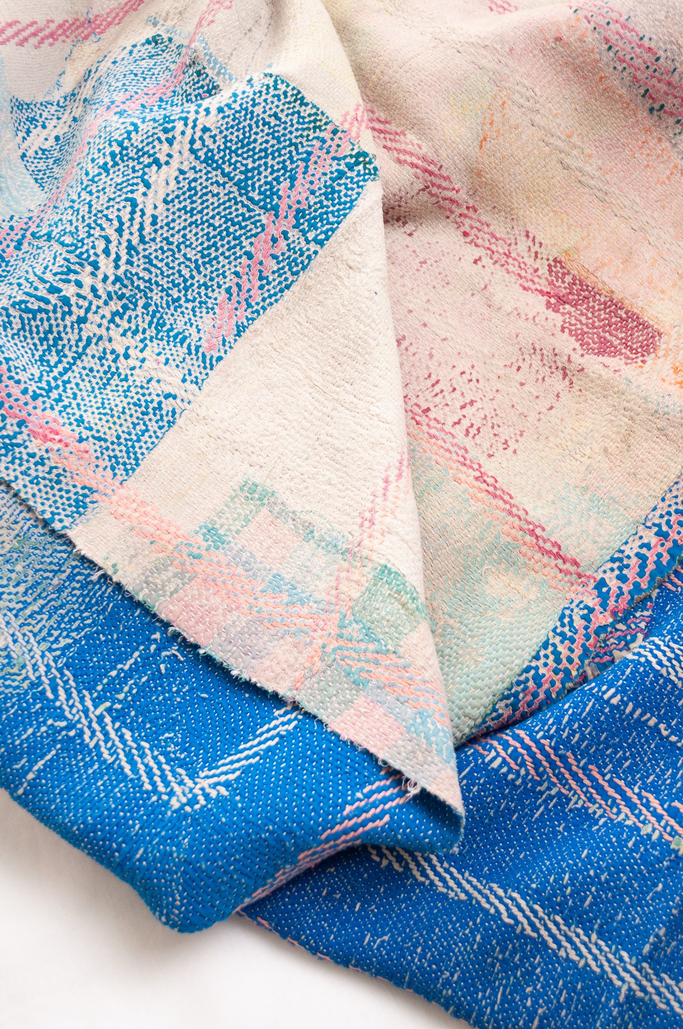 Vintage kantha quilt in cobalt blue stitched in pink and white.