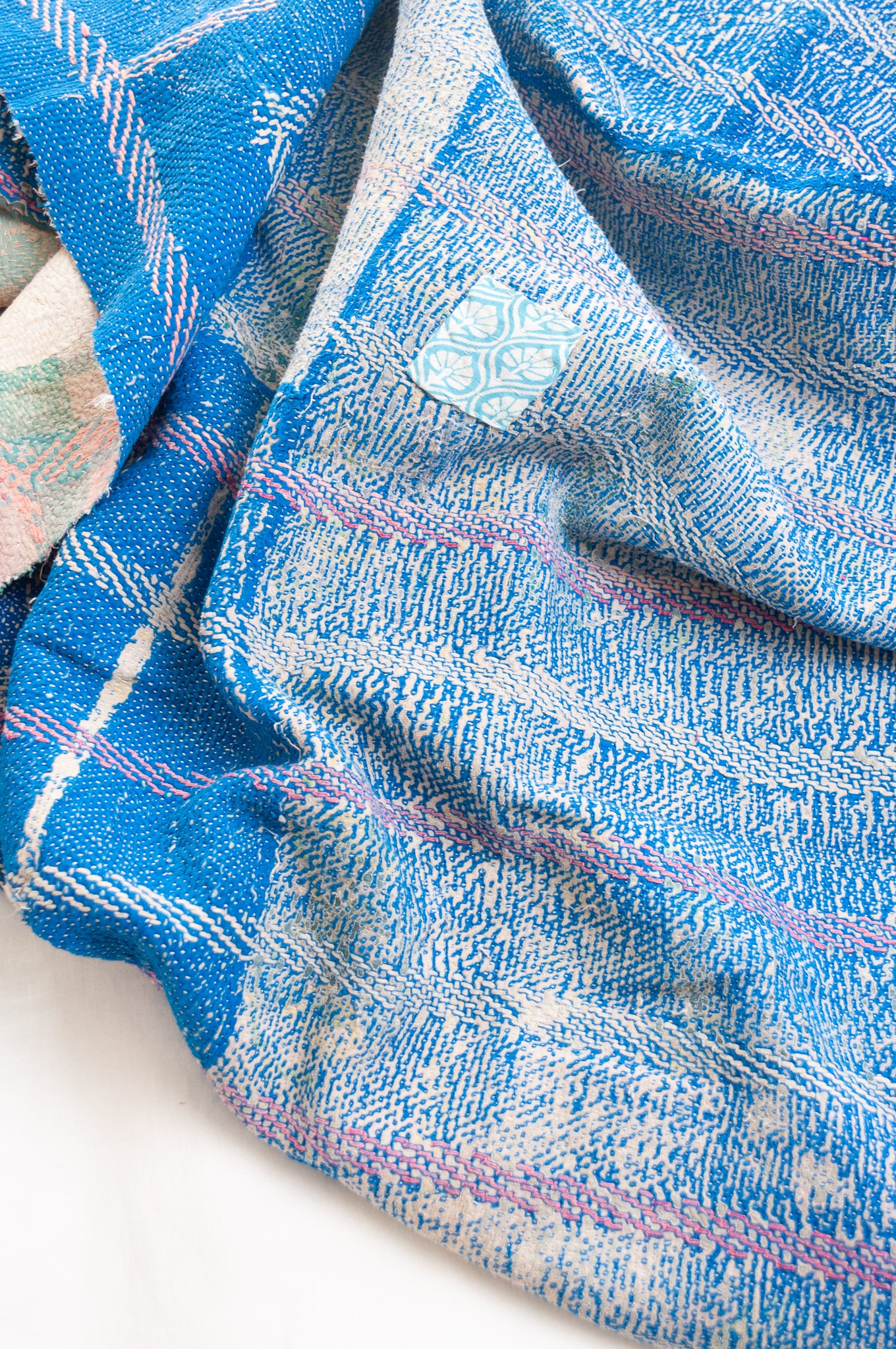 Vintage kantha quilt in cobalt blue stitched in pink and white.