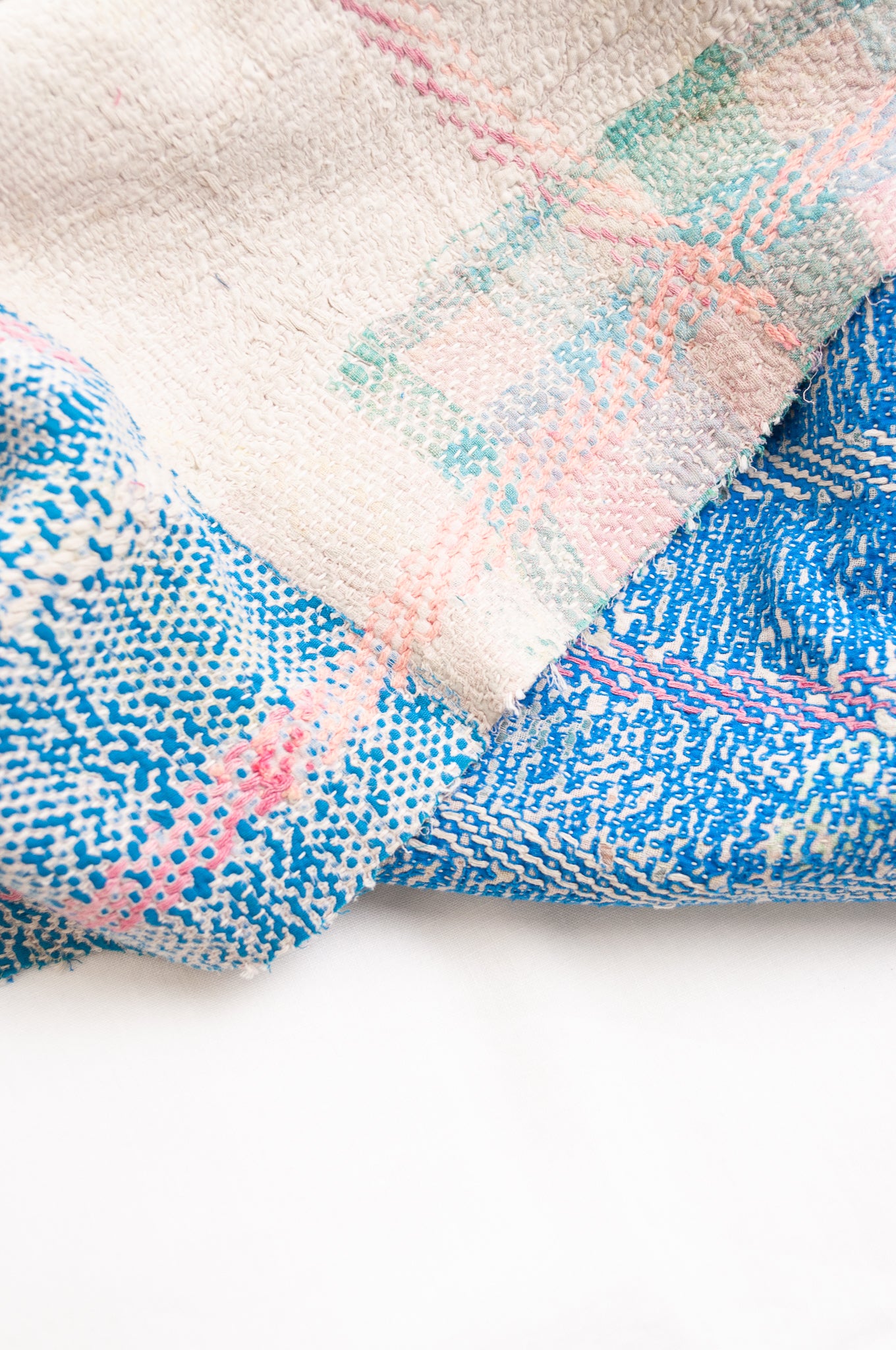 Vintage kantha quilt in cobalt blue stitched in pink and white.