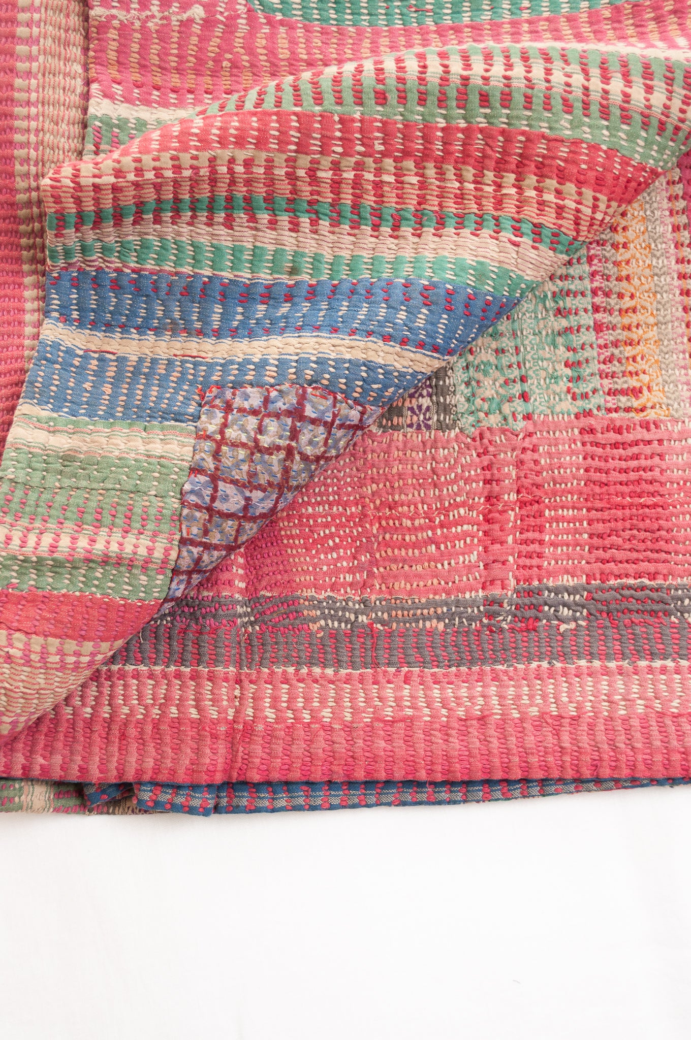 Vintage kantha quilt in deep pink, blue and green, and floral braid stripes.