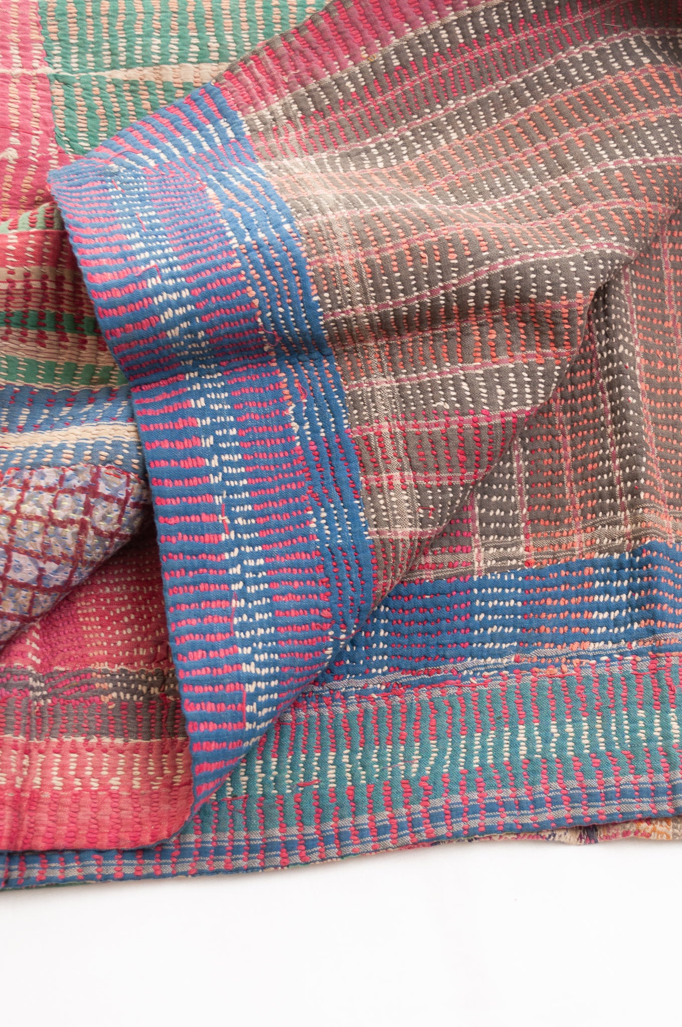 Vintage kantha quilt in deep pink, blue and green, and floral braid stripes.