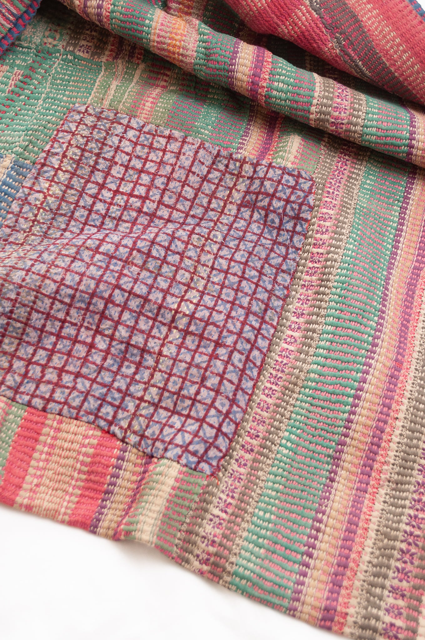 Vintage kantha quilt in deep pink, blue and green, and floral braid stripes.