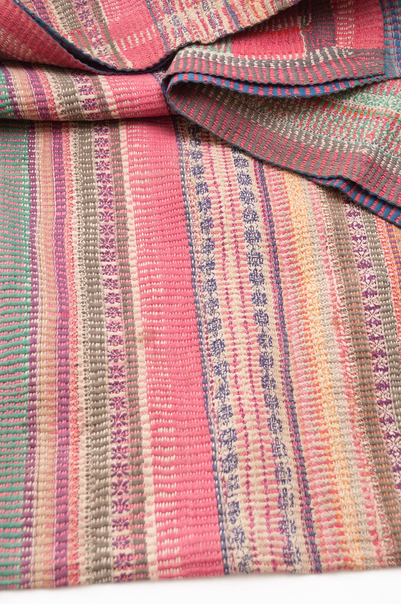 Vintage kantha quilt in deep pink, blue and green, and floral braid stripes.