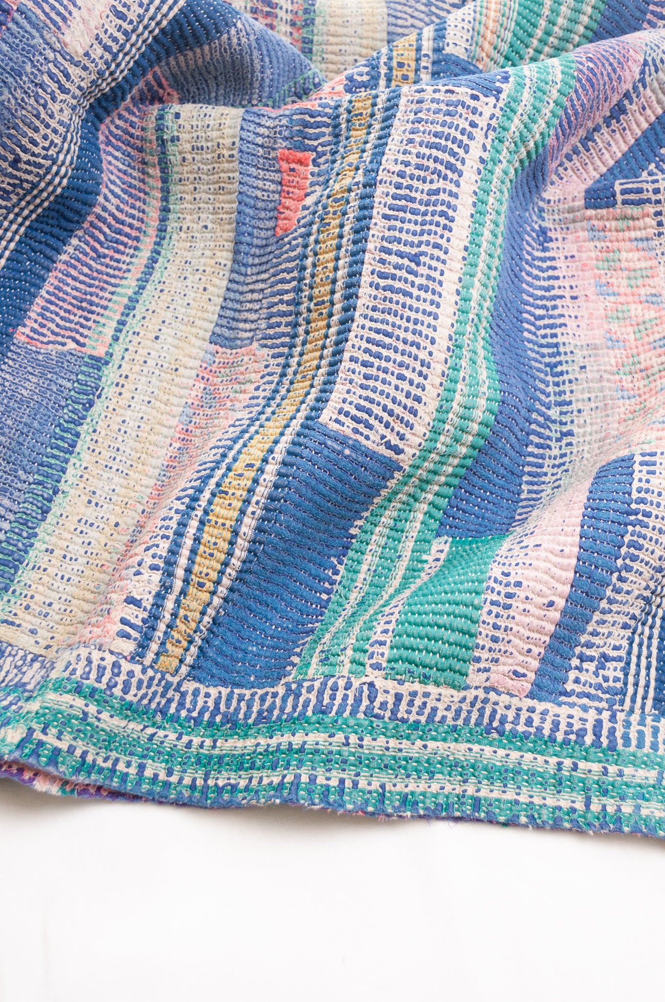 Vintage kantha quilt in deep pink, bluel lavender and green stripes.