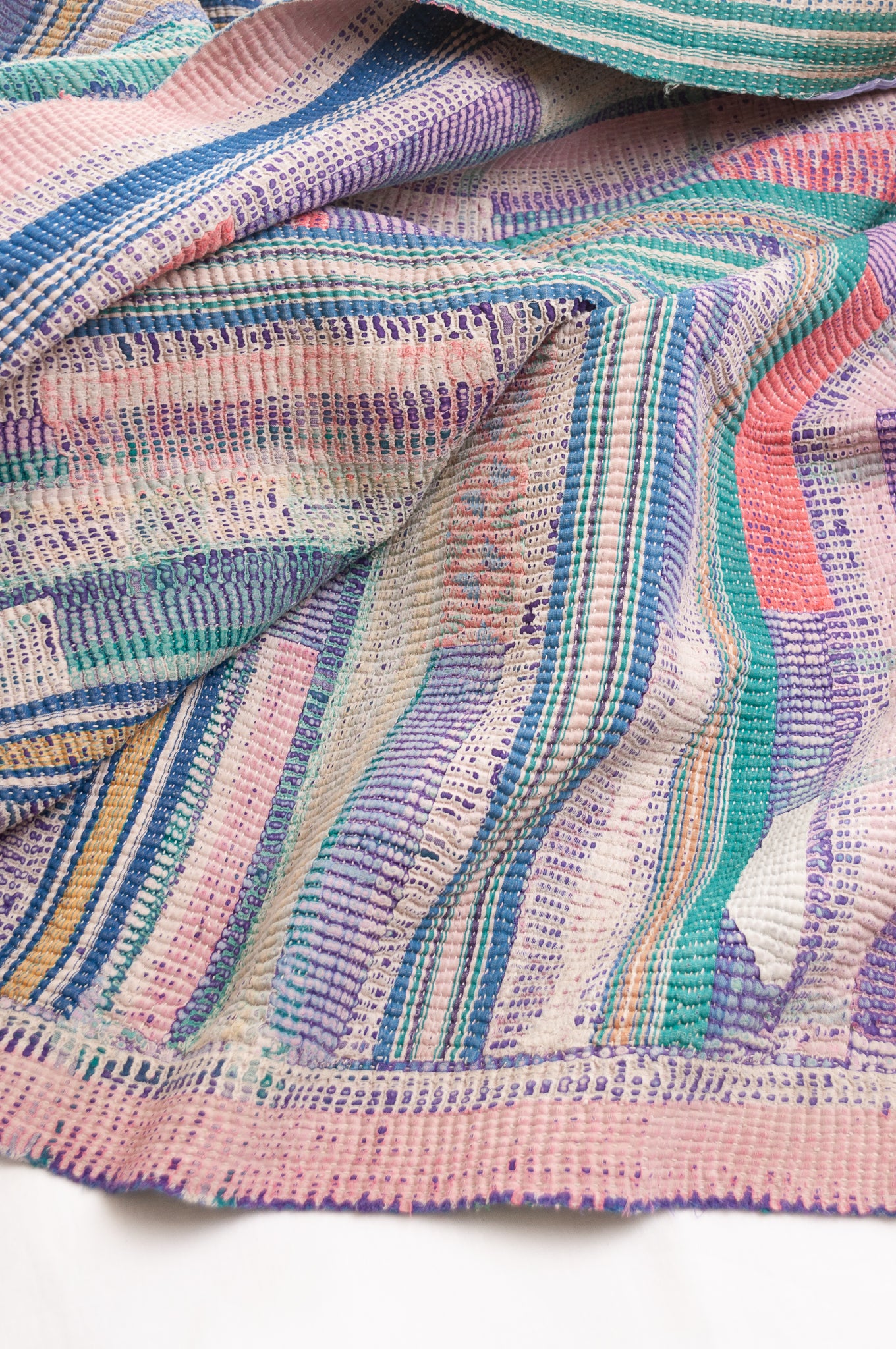 Vintage kantha quilt in deep pink, bluel lavender and green stripes.
