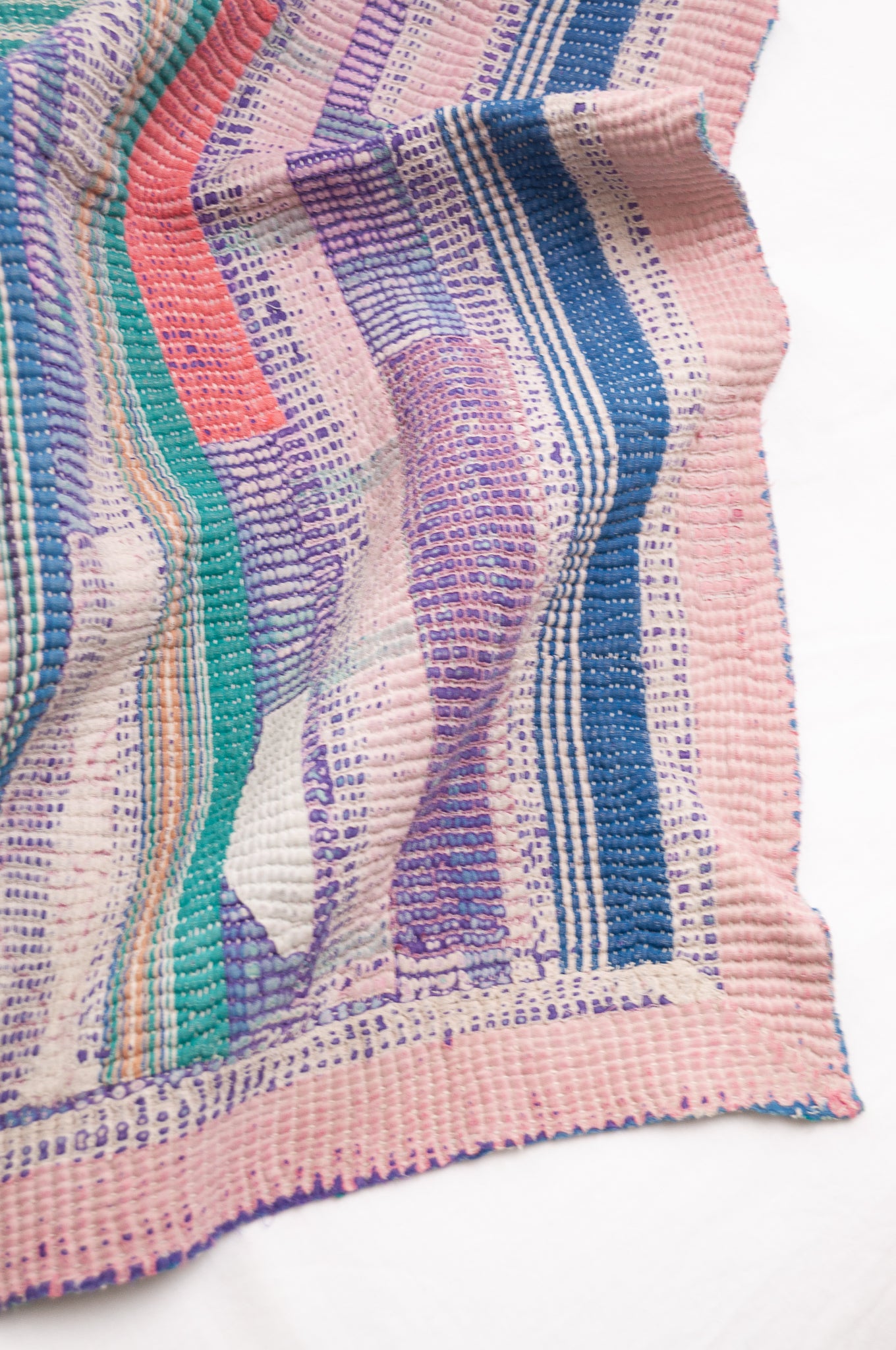 Vintage kantha quilt in deep pink, bluel lavender and green stripes.