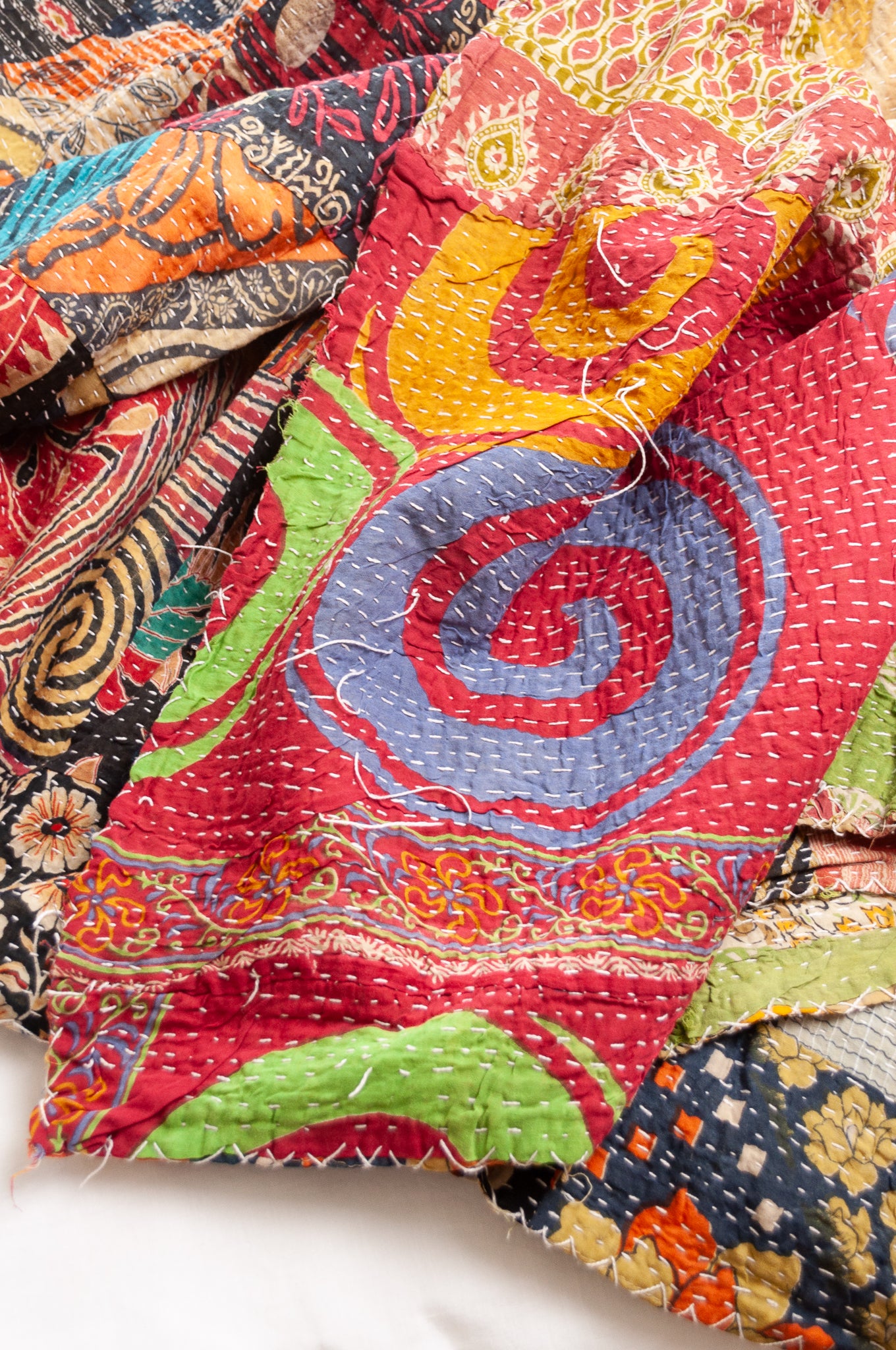Vintage patchwork kantha quilt im multiple prints with black base.