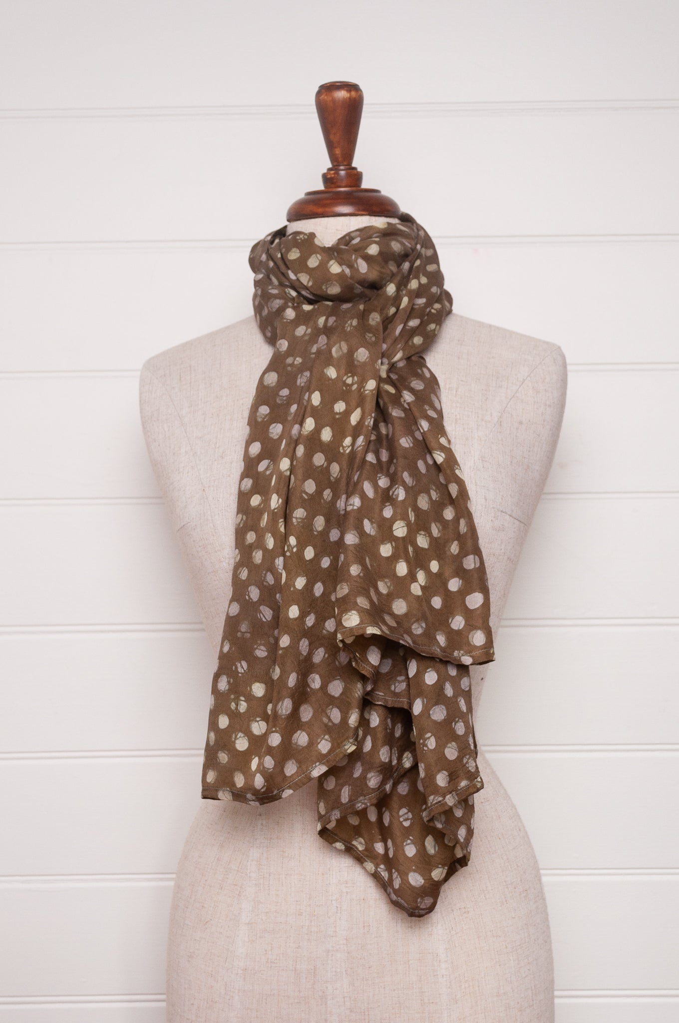 Pure silk shibori dyed scarf in deep olive green with white spots.