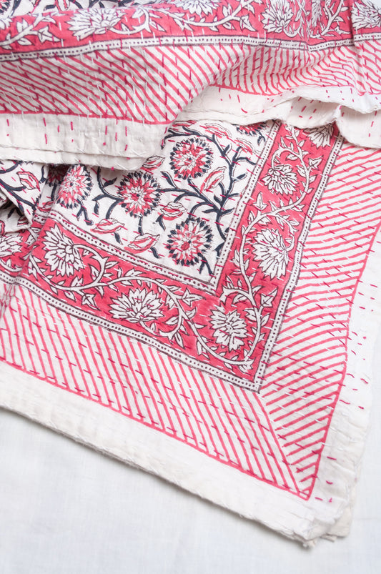 Cotton kantha quilt in raspberry pink floral on white.