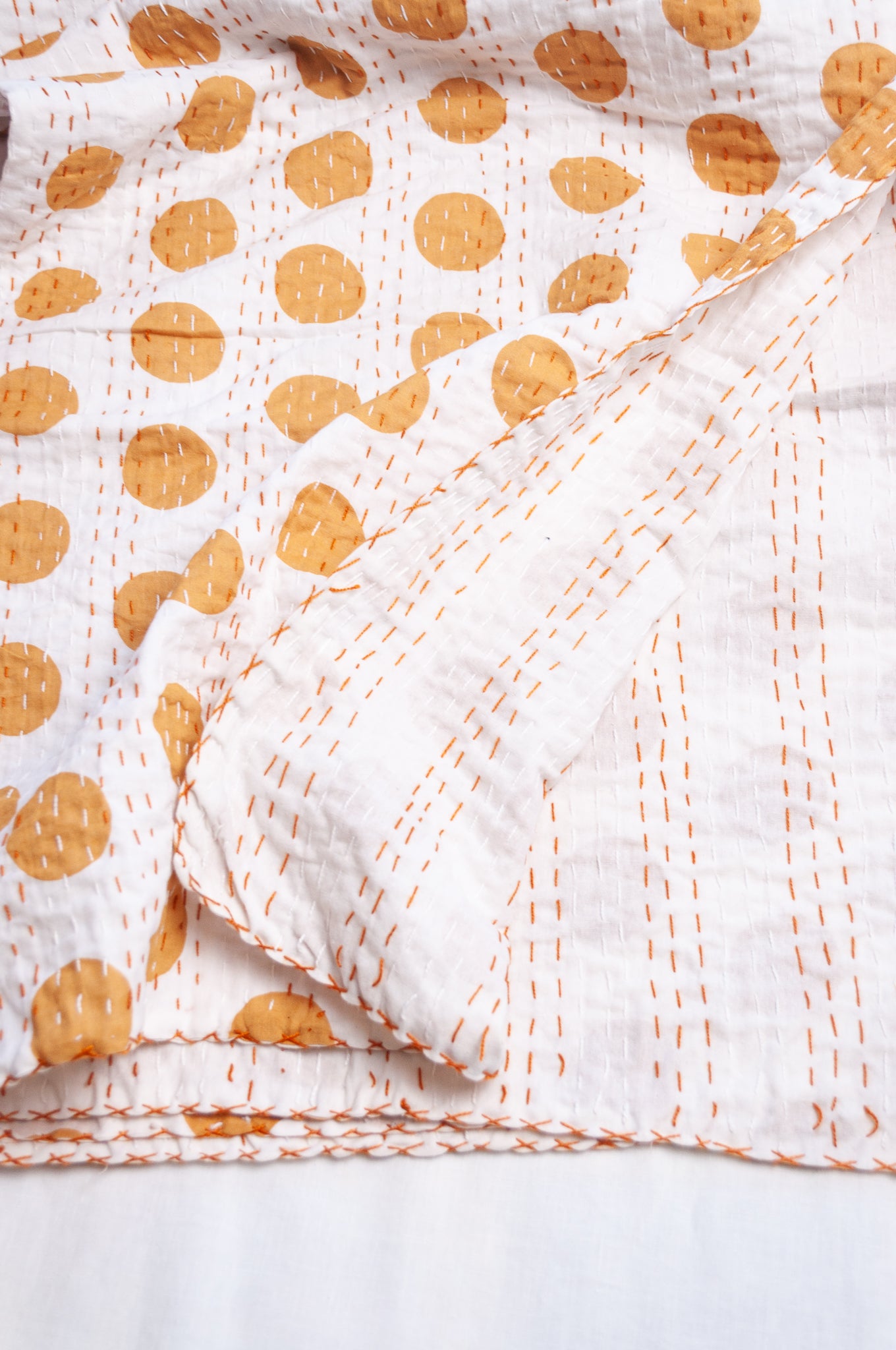 Indigo mustard spot on white cotton kantha quilt.