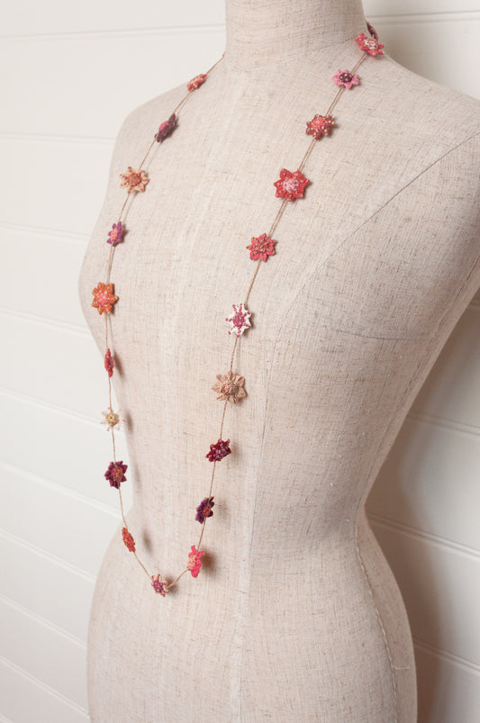 Sophie Digard star flower embroidered linen necklace in pinks and reds.