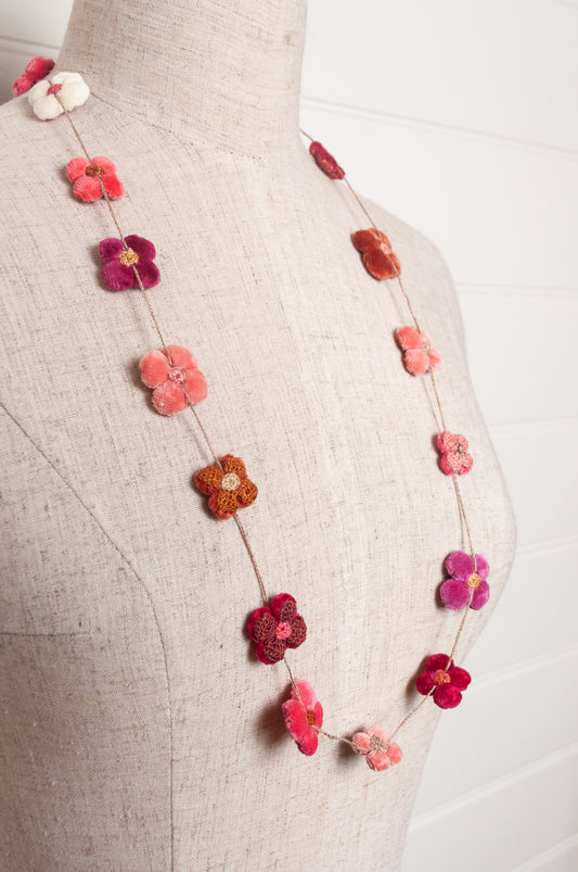 Sophie Digard velvet four petal flower necklace in pinks and reds.