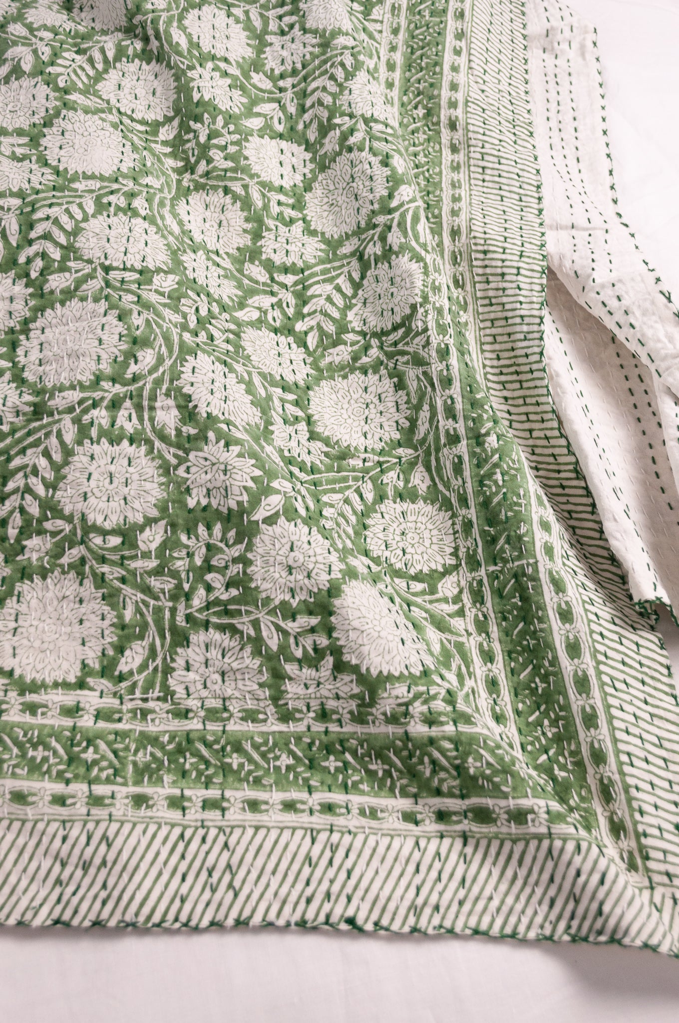 Cotton kantha quilt in grass green and white floral.
