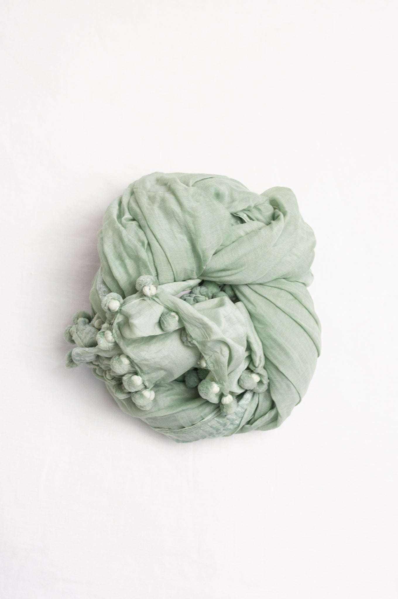 Silk cotton pom pom scarf in light sage green.