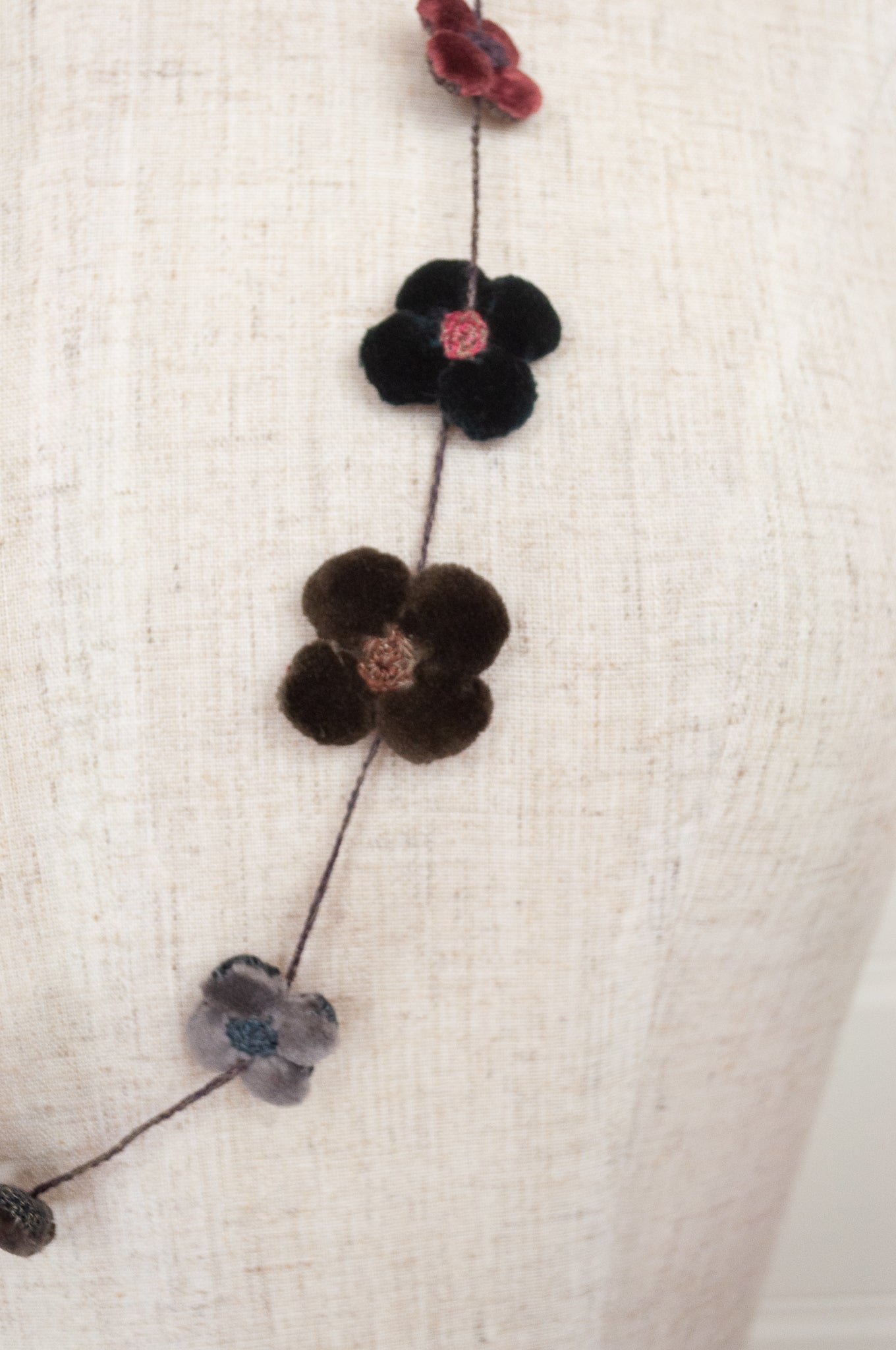 Classic handmade Sophie Digard necklace is a string of beautiful velvet flowers, backed with linen embroidery in a cool winter palette, Dingle.