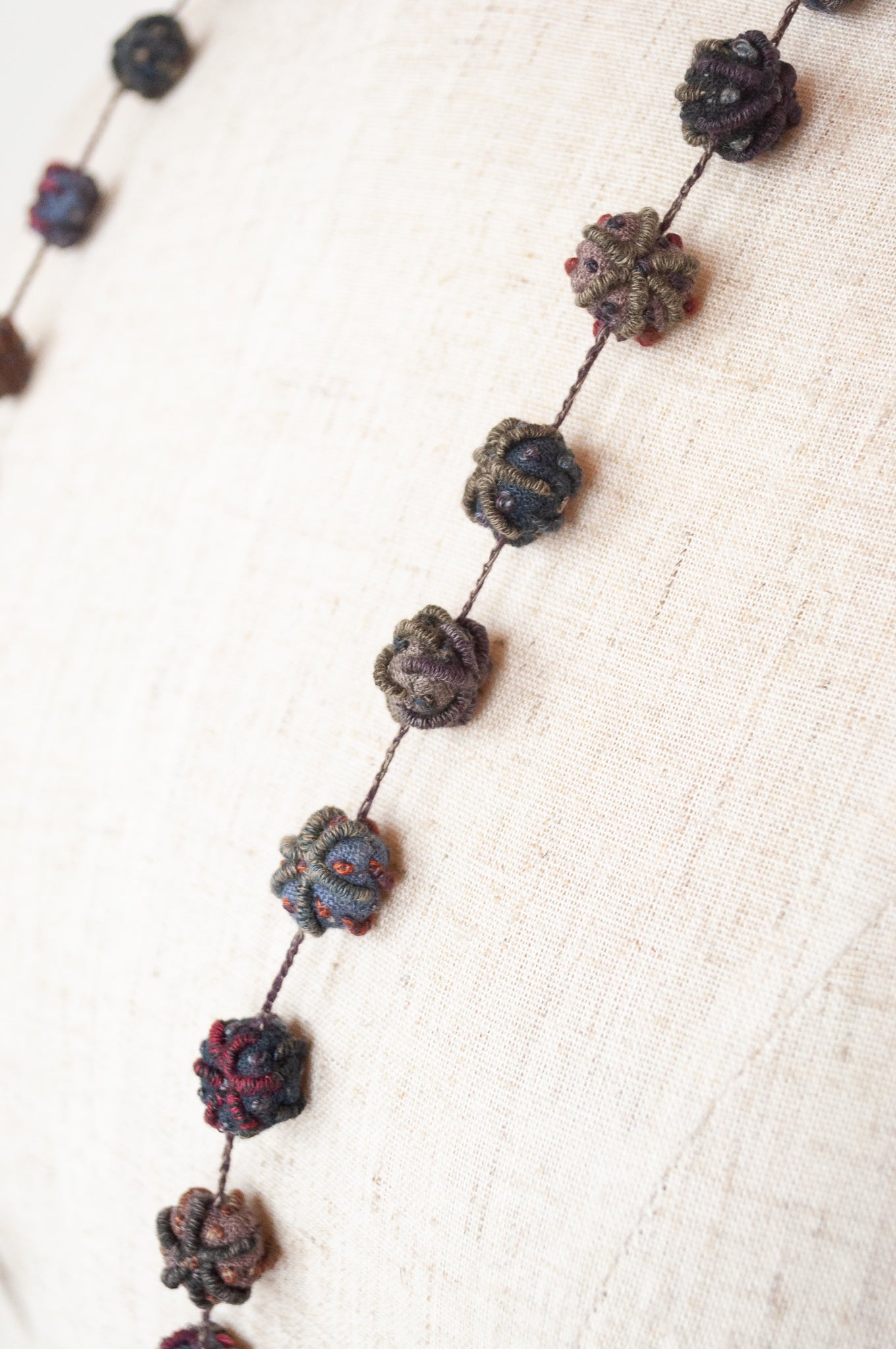 Classic handmade Sophie Digard necklace is a string of embroidered fabric beads, in a cool winter palette, Dingle.