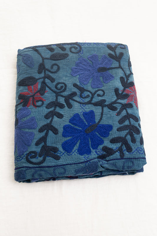 Vintage indigo kantha quilt embroidered Suzani style in shades of indigo with red highlights.