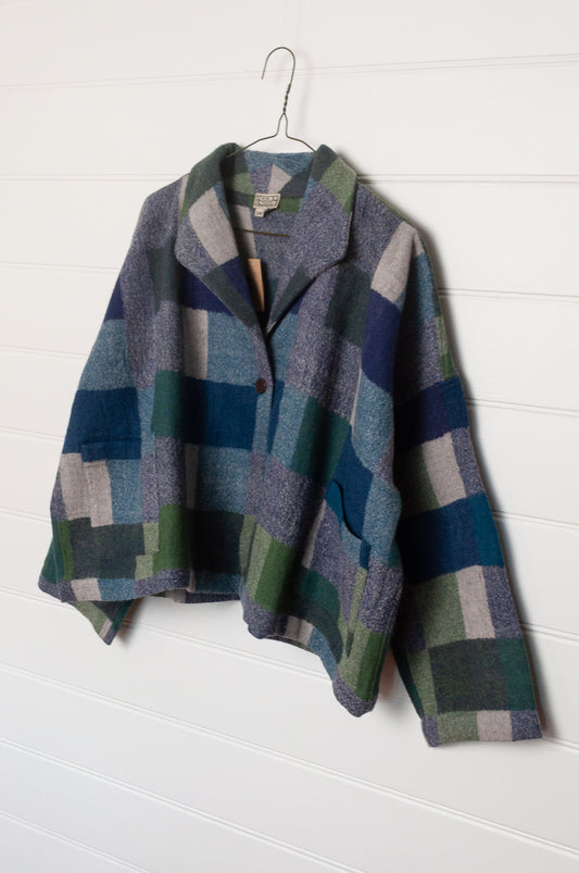 Neeru Kumar handwoven wool Coco jacket with a geometric blanket block pattern in shades of blue, green, gray, and beige