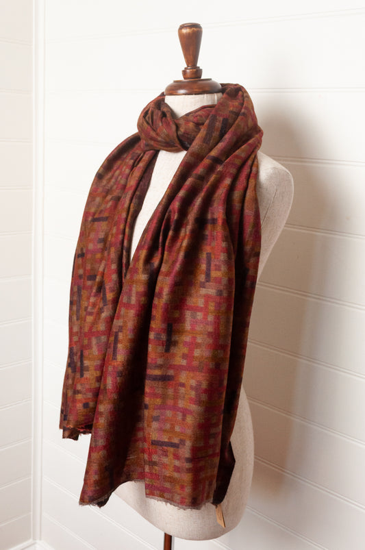 Neeru Kumar superfine wool scarf digital print check pattern in rust red, brown, and dark charcoal gray.