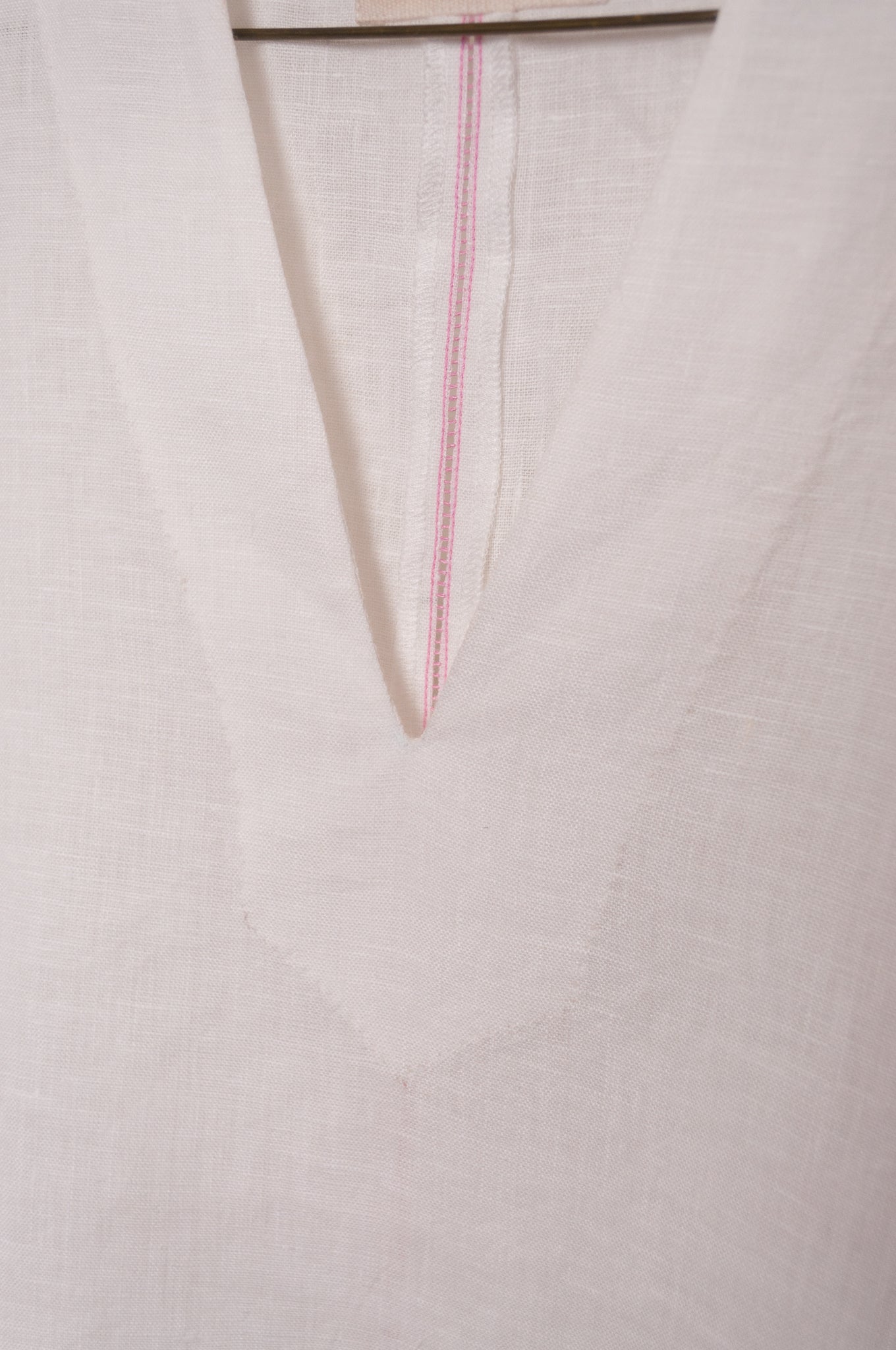 Manan Hoshi top with V-neck and elasticated short sleeves in white linen.