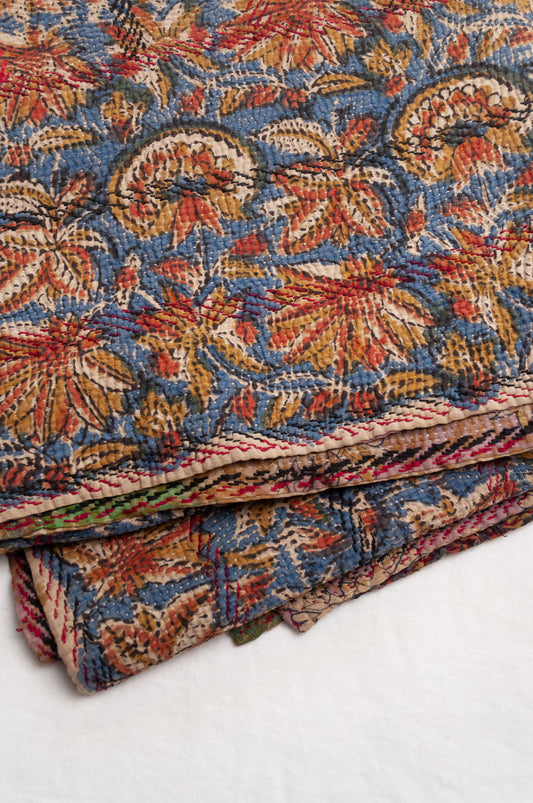 Vintage kantha quilt Bagru blockprinted in indigo, mustard and rust brown, floral design with red and dark green embroidery.