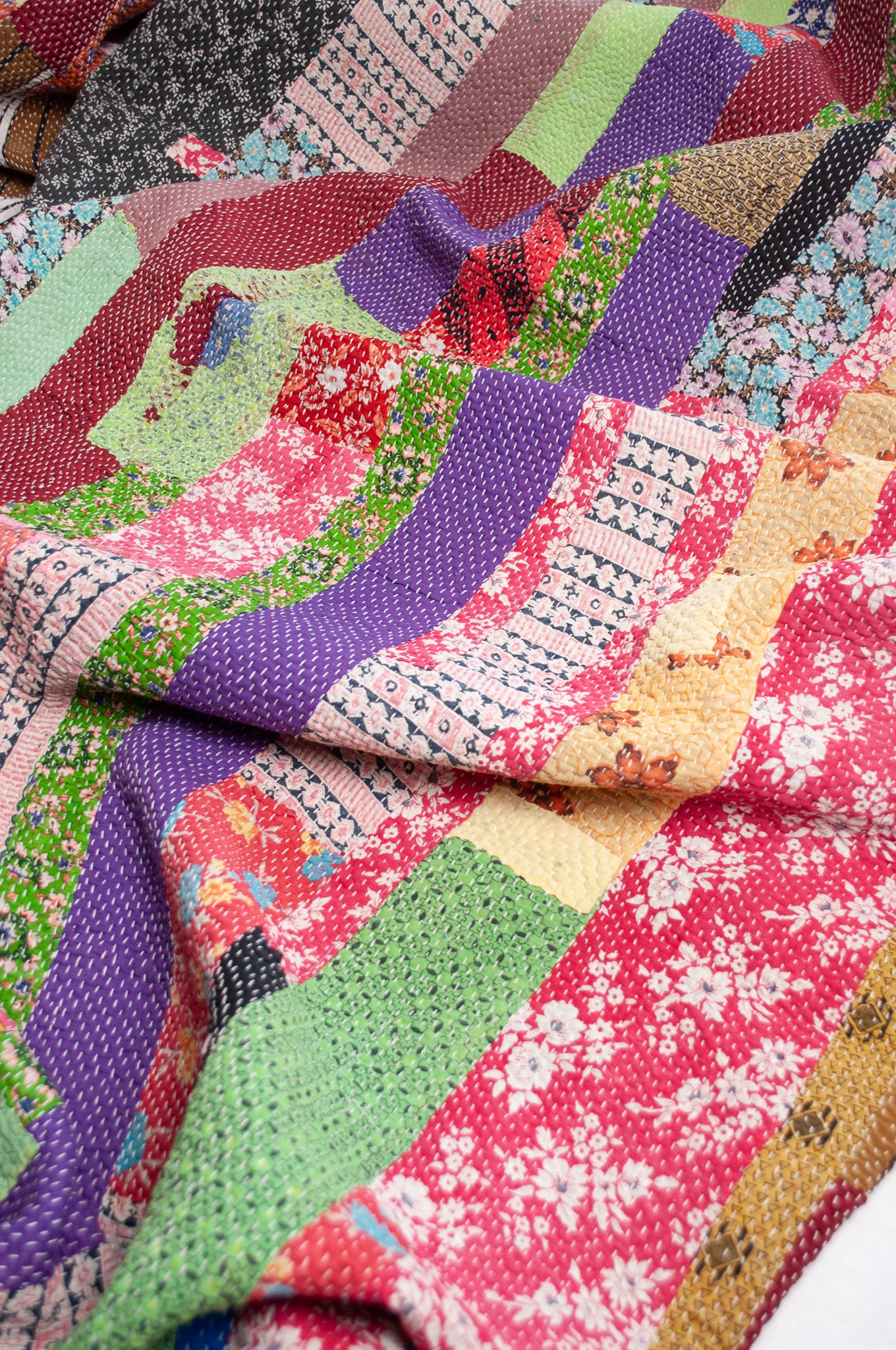 Striped patchwork kantha quilt featuring retro floral prints and plain colours.