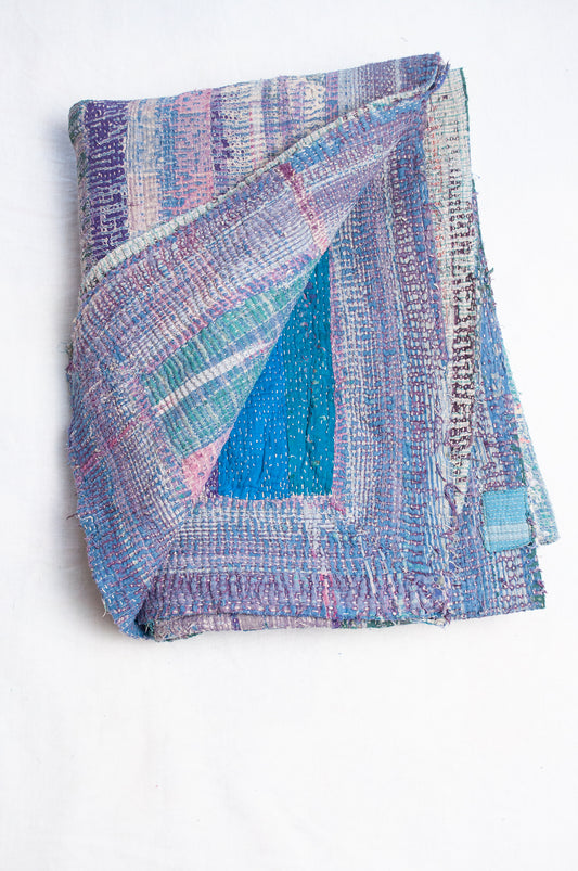 Faded striped kantha quilt in pinks, blues and greens.