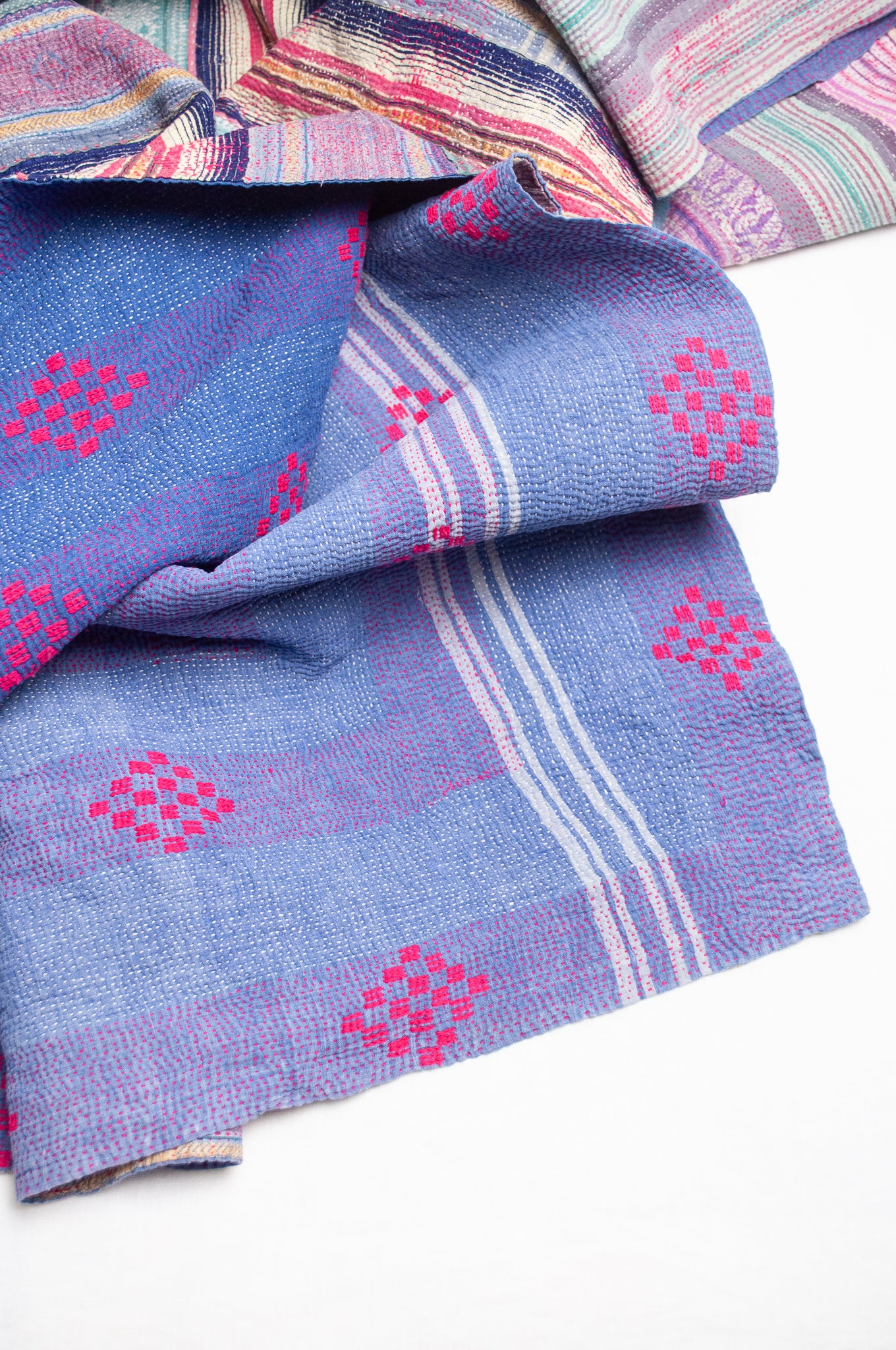 Striped vintage kantha quilt in mauve and green.