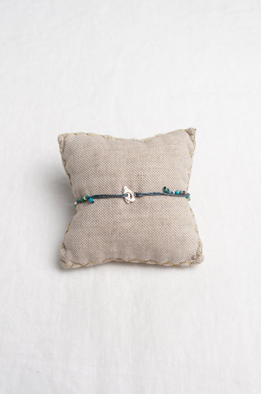 Mary Gaitani hand tooled silver charms on stranded cords with turquoise beads.