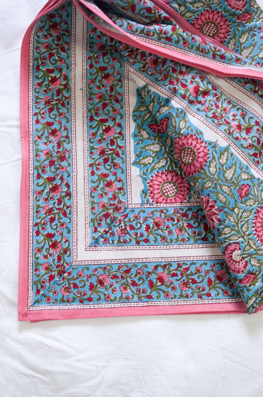Pure cotton floral blockprint tablecloth in shades of pink on aqua blue.