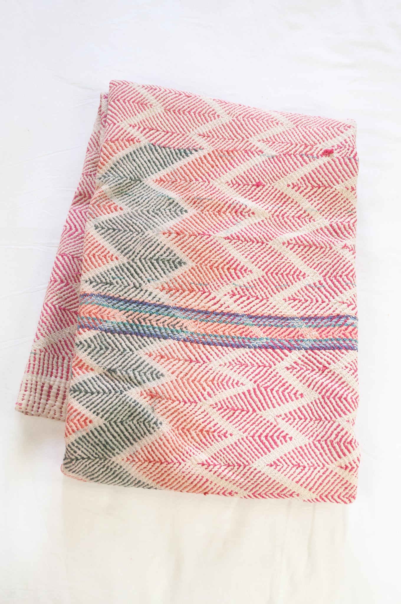 Vintage lohori wave stitched kantha quilt in red, pink, green and blue on white.