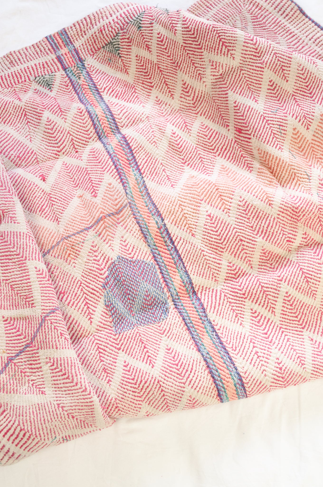 Vintage lohori wave stitched kantha quilt in red, pink, green and blue on white.
