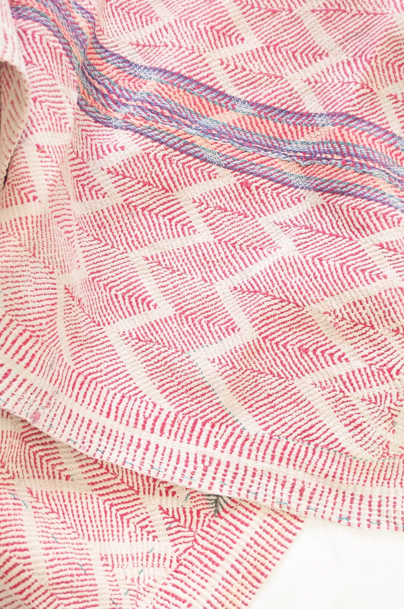 Vintage lohori wave stitched kantha quilt in red, pink, green and blue on white.