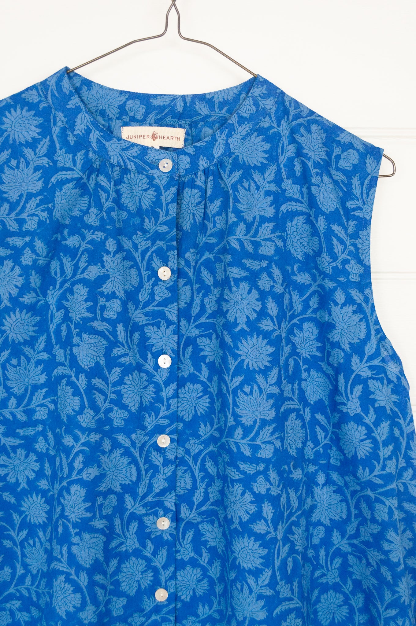 Juniper hearth Zoe dress button up sleeveless with waist ties, made from cotton cornflower blue blockprint floral.