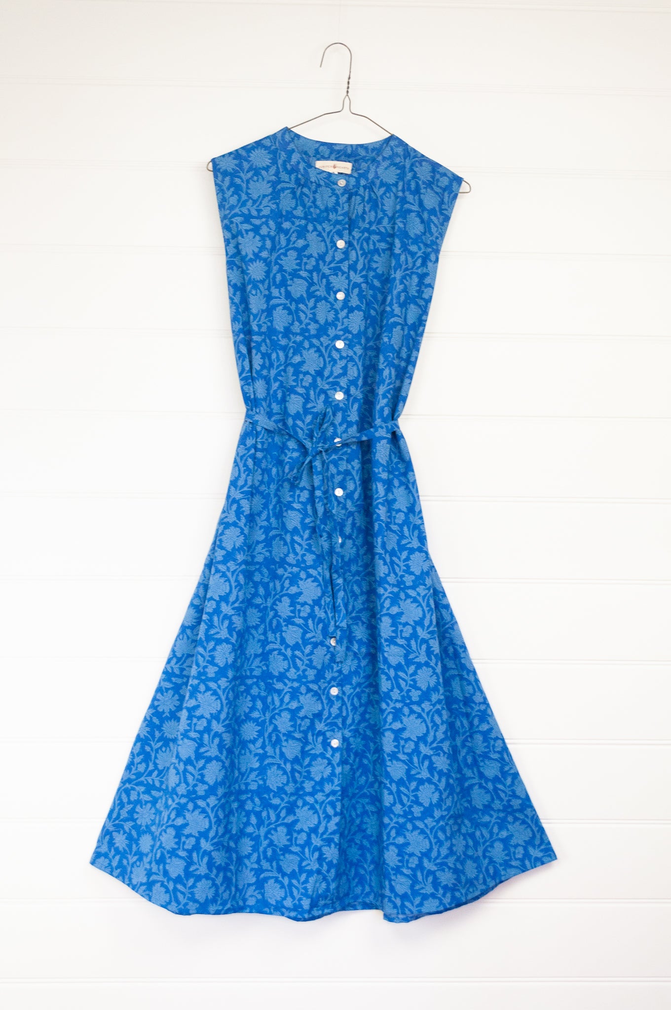 Juniper hearth Zoe dress button up sleeveless with waist ties, made from cotton cornflower blue blockprint floral.