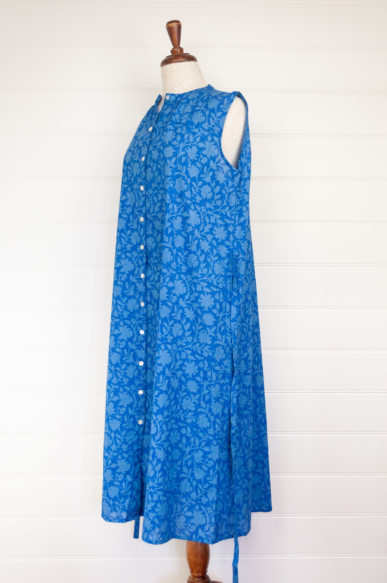 Juniper hearth Zoe dress button up sleeveless with waist ties, made from cotton cornflower blue blockprint floral.
