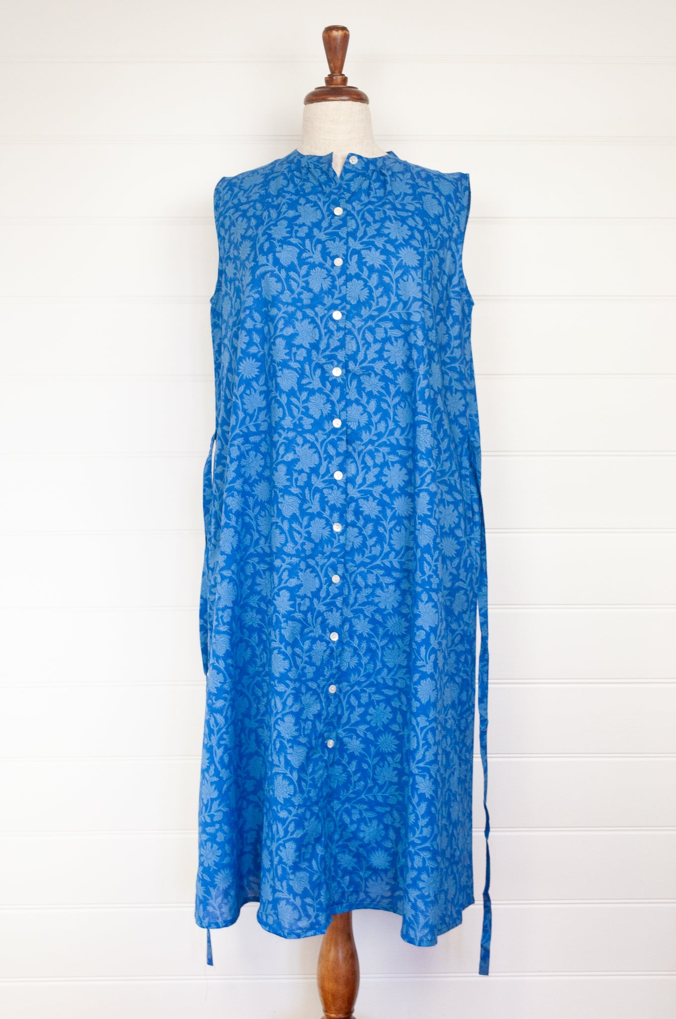 Juniper hearth Zoe dress button up sleeveless with waist ties, made from cotton cornflower blue blockprint floral.