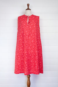 Juniper Hearth Stella dress in cherry pink red blockprint floral cotton, A-line sleeveless with front ties.