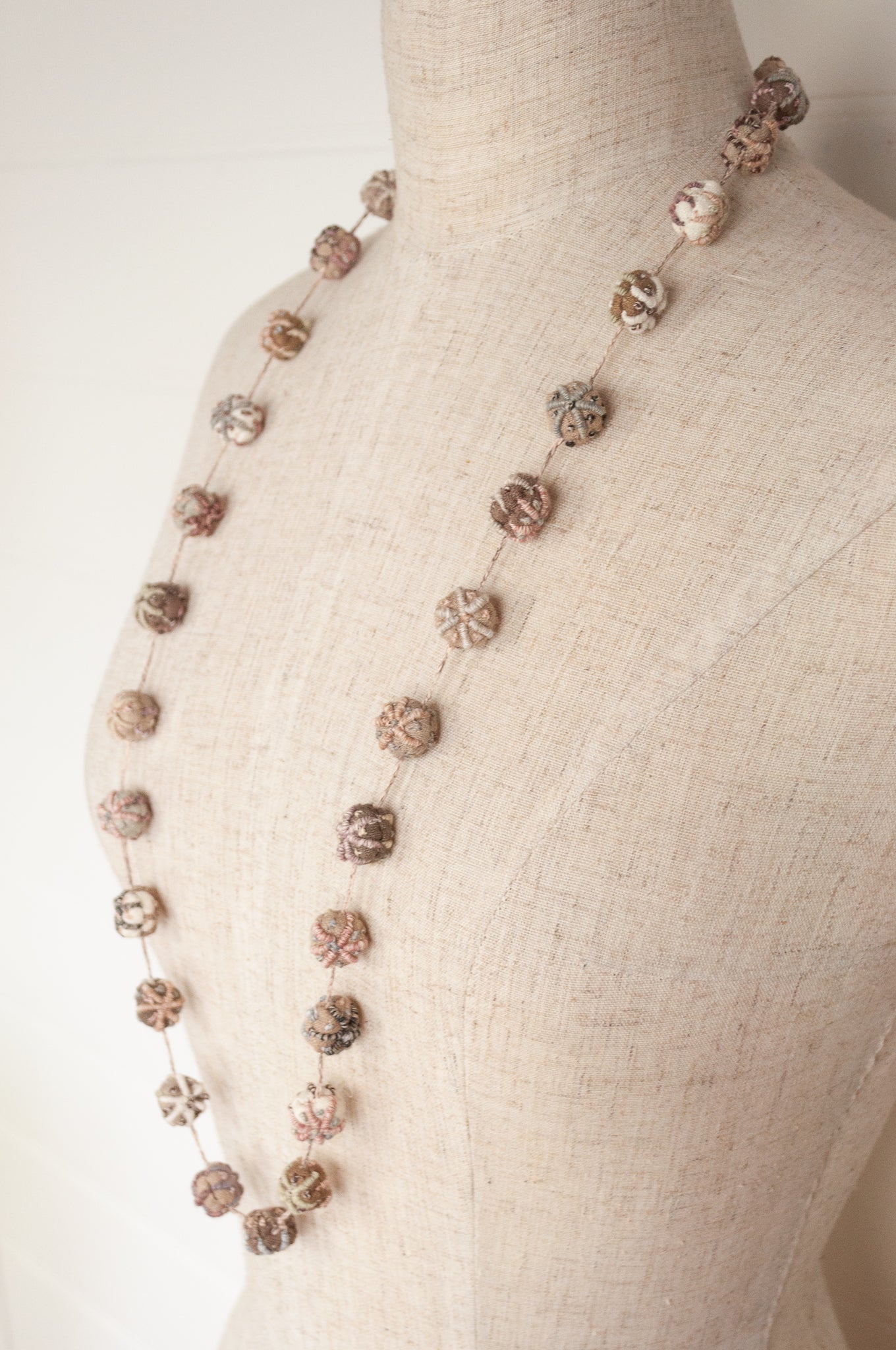Sophie Digard hand made embroidered linen beads in neutral tones.