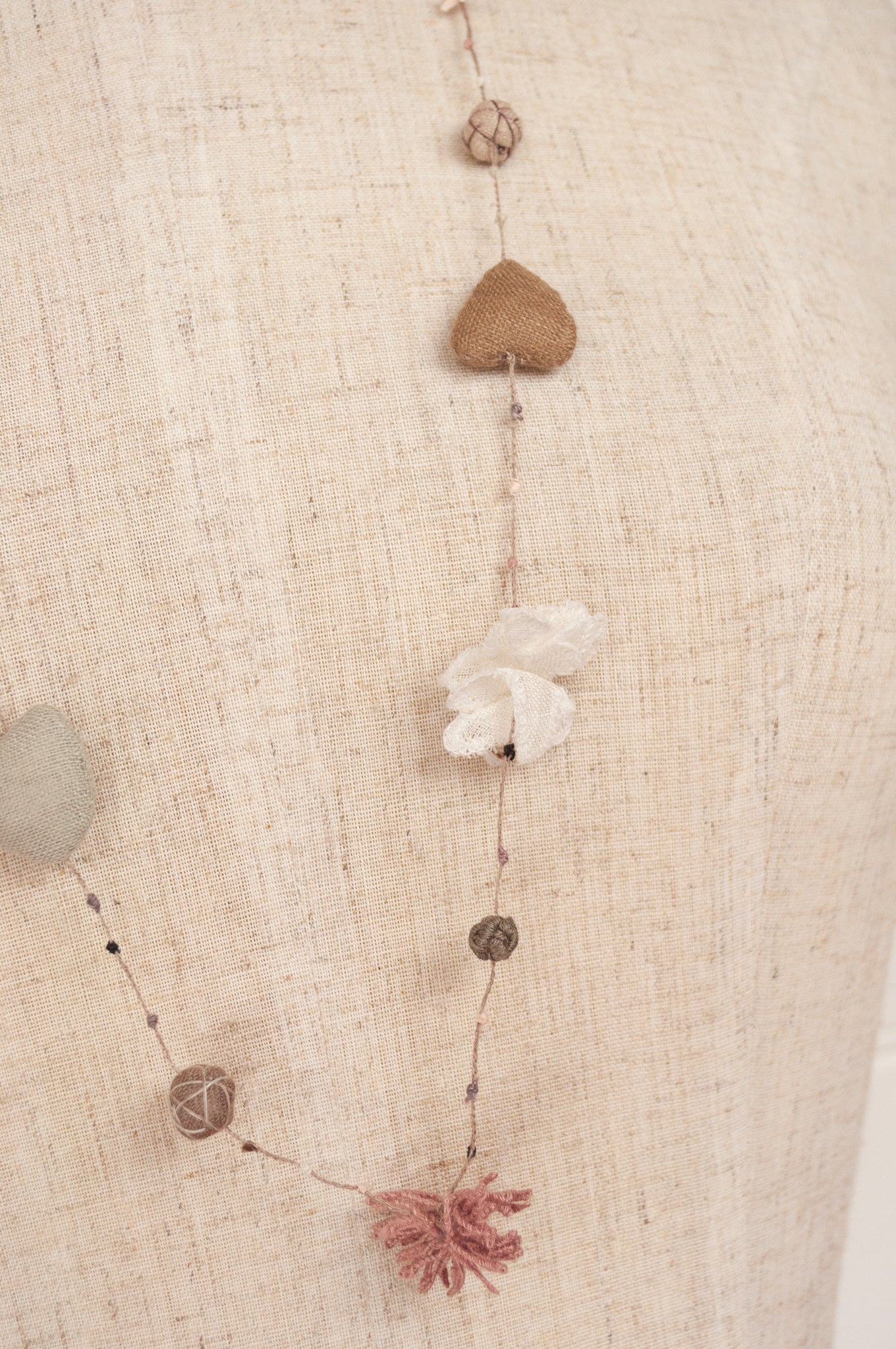 Sophie Digard hand made linen necklace, a string of hearts, flowers and beads in neutral tones.