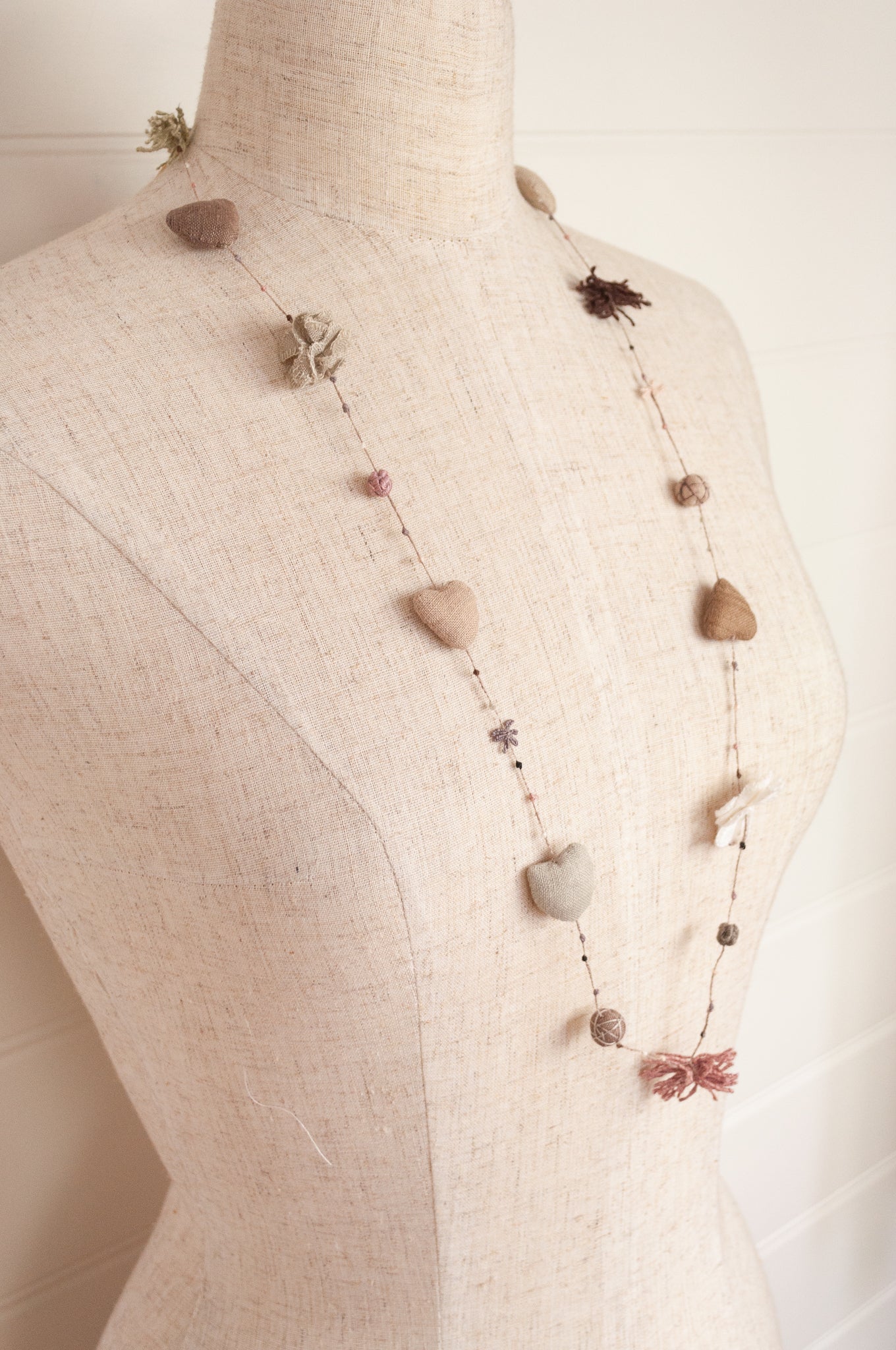 Sophie Digard hand made linen necklace, a string of hearts, flowers and beads in neutral tones.