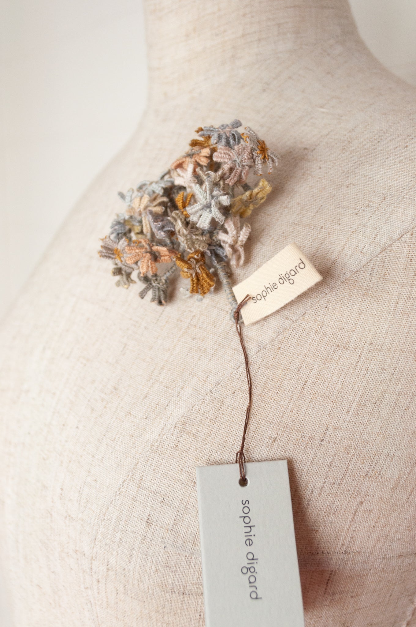 Sophie Digard floral brooch, hand embroidered and crocheted in line in soft neutral tones.