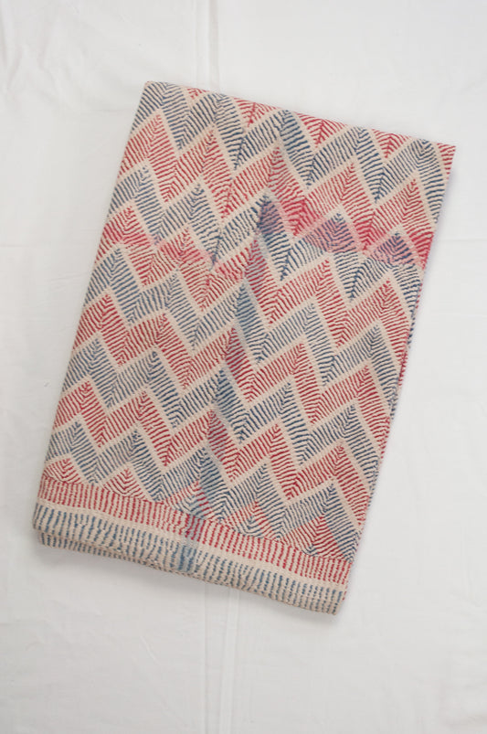 Traditional lohori wave kantha quilt red and blue stitching on white background.