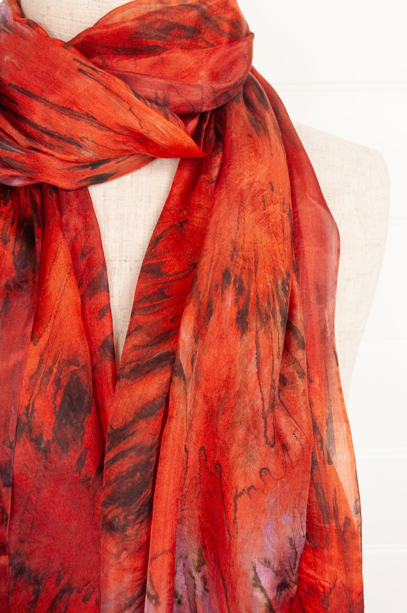 Tie dye silk scarf in shades of orange, magenta and bronze.