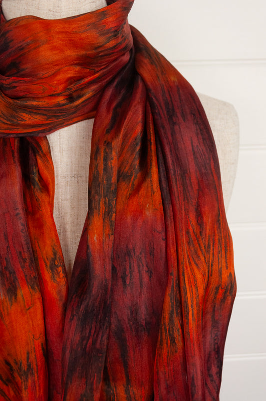 Tie dye silk scarf in shades of burnt orange, deep red and bronze.