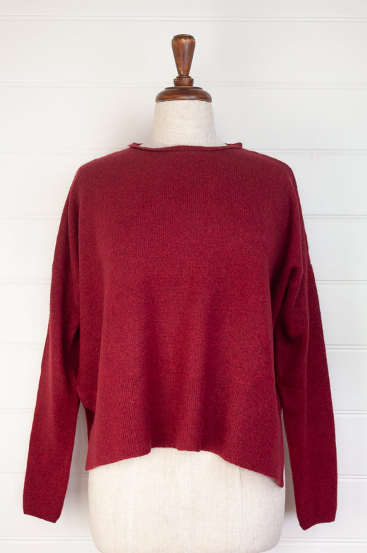 Baby yak sweater with round neck and side slits in cherry red.