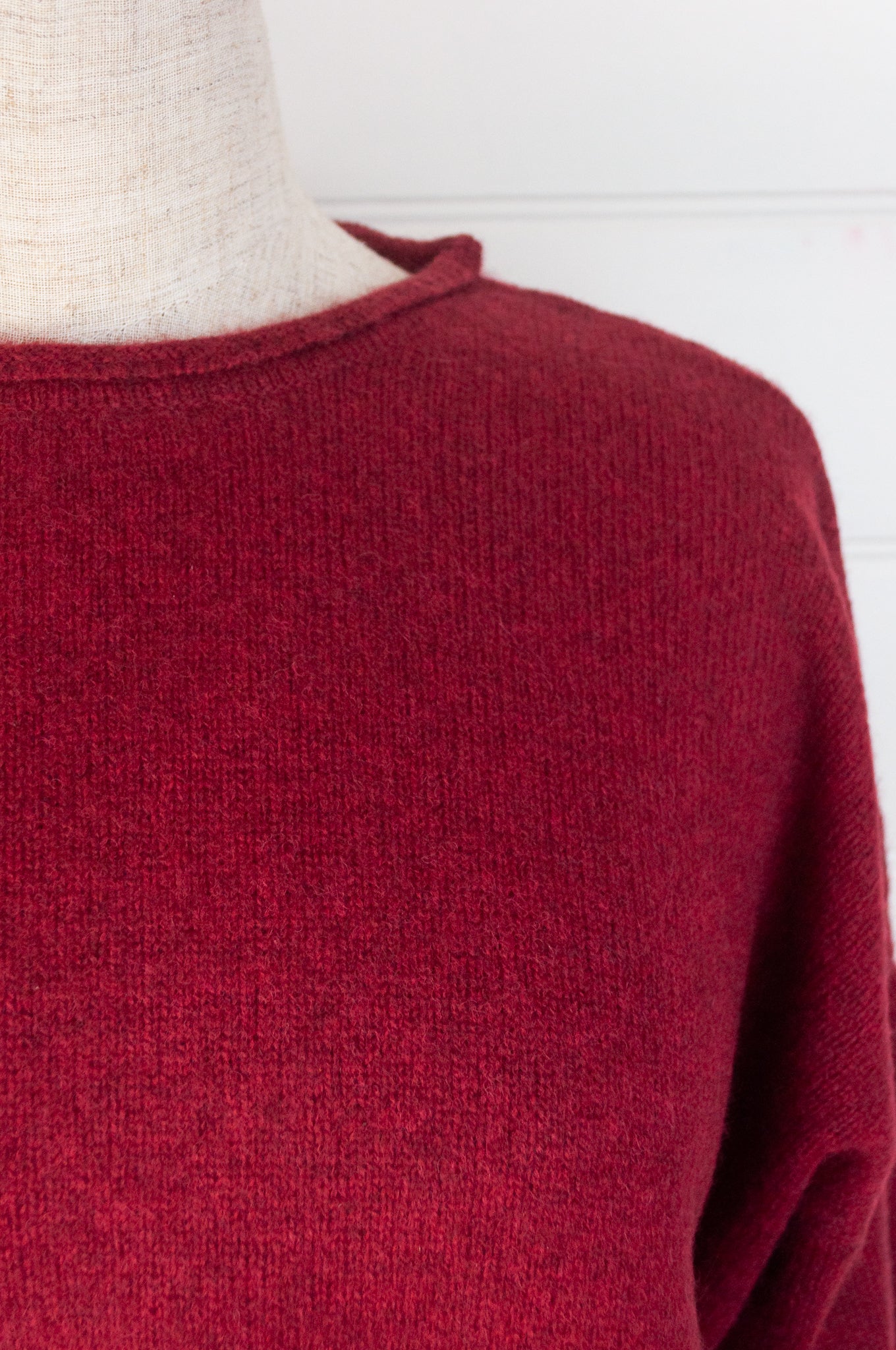 Baby yak sweater with round neck and side slits in cherry red.