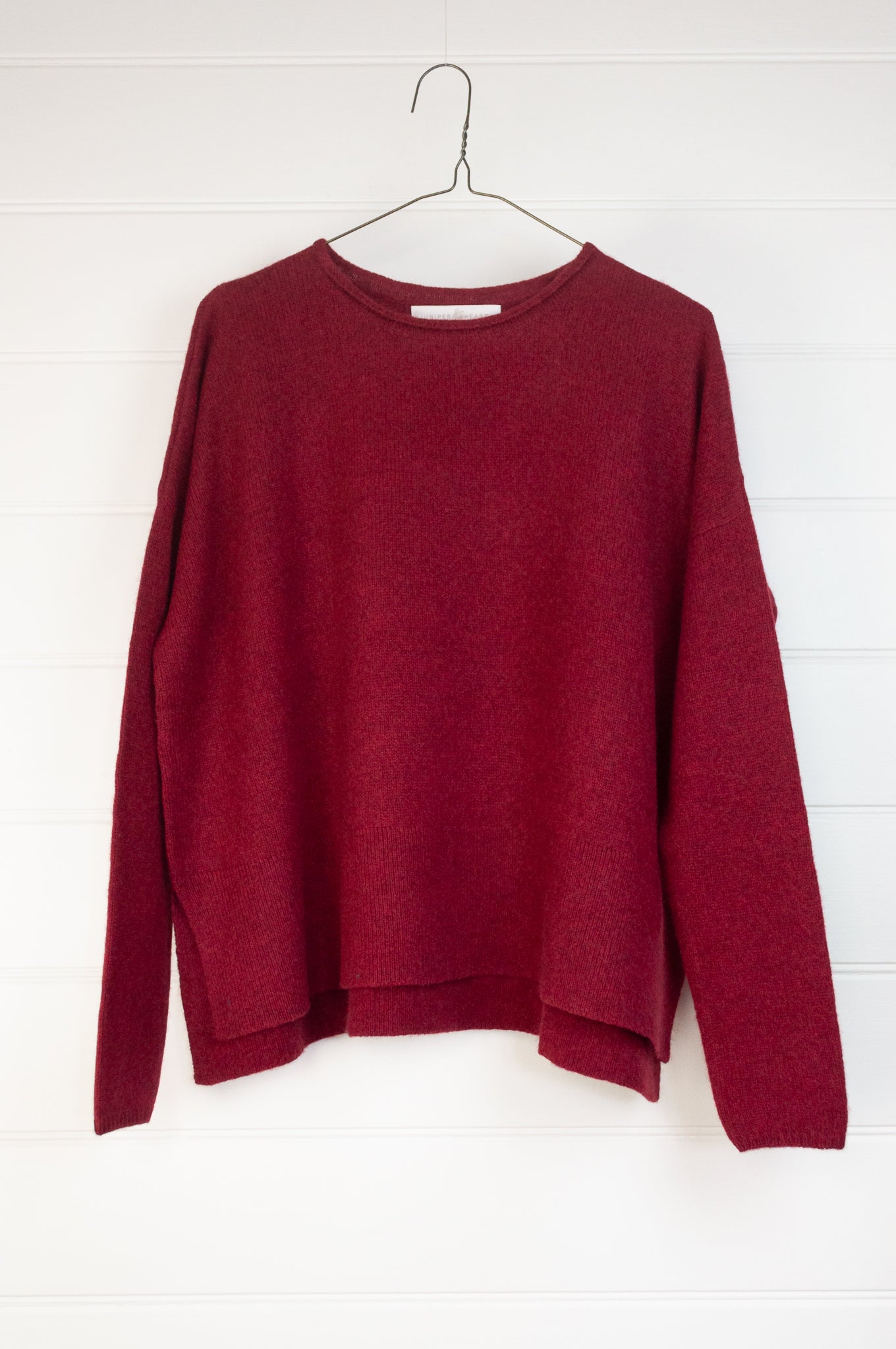 Baby yak sweater with round neck and side slits in cherry red.